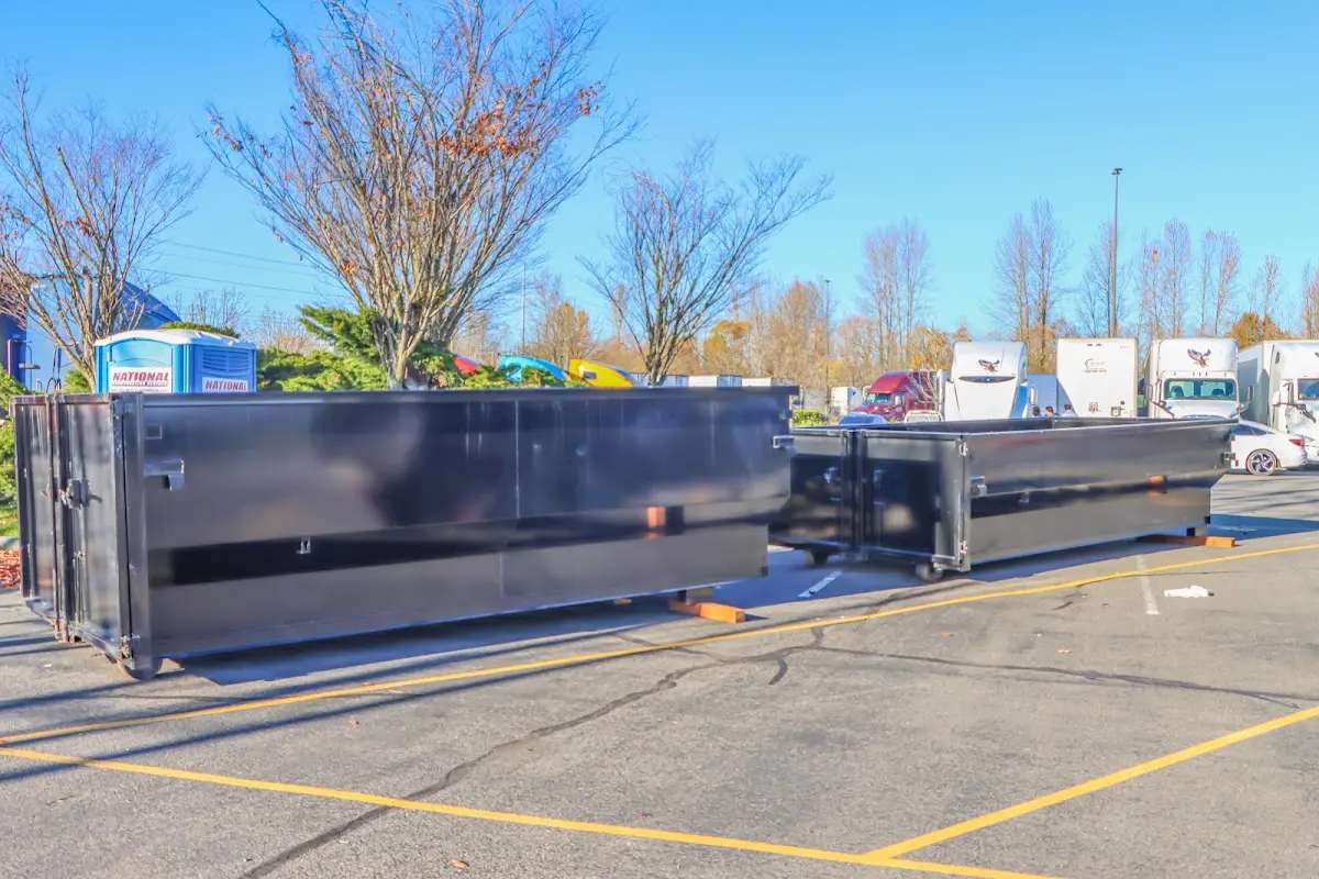 Professional dumpster rental service with roll-off container on residential driveway in Ottumwa